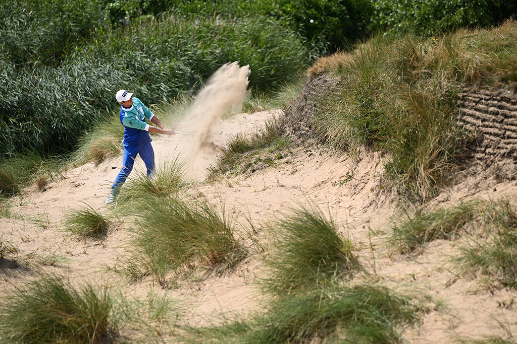 Viktor Hovland faces a tricky shot from the sand at the back of the 17th green